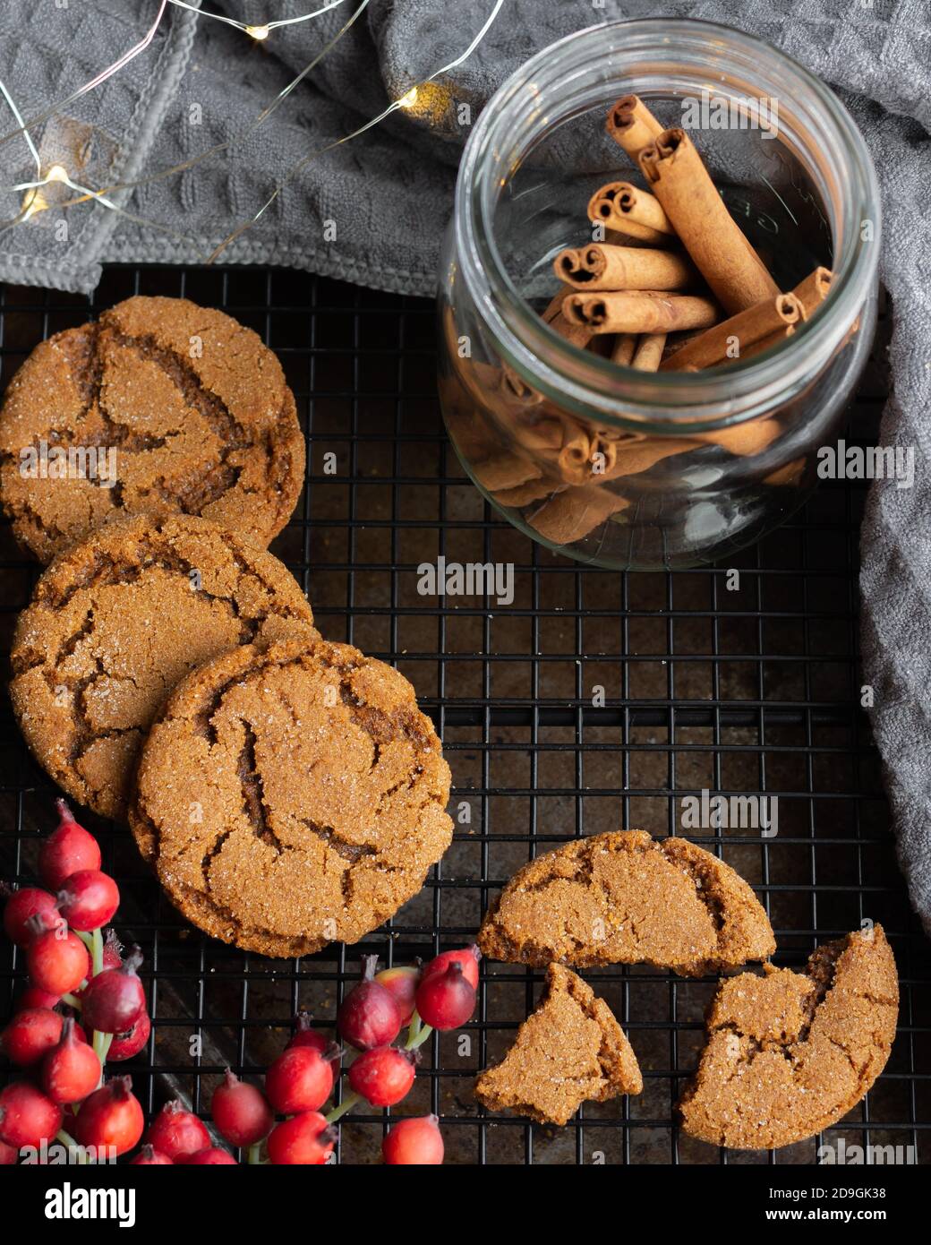 Ingwer Snap Cookies mit Feiertagsbeleuchtung, Beeren und Zimtstangen für Weihnachten Stockfoto