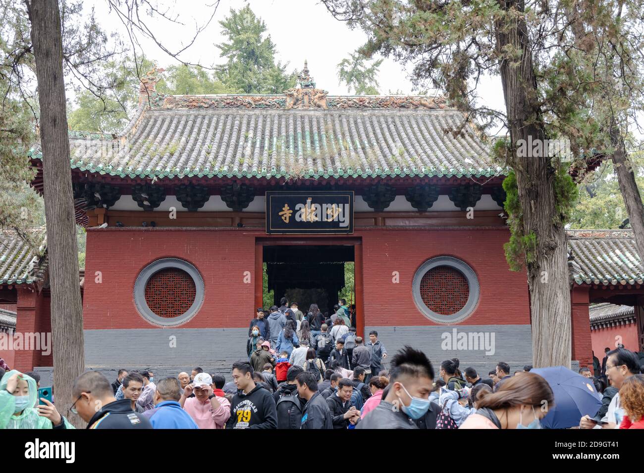 Schwärme von Besuchern, in Regenmäntel verschiedener Farben gekleidet, besuchen Shaolin Kloster, auch bekannt als der Shaolin Tempel, die und seine Pagode Wald wer Stockfoto