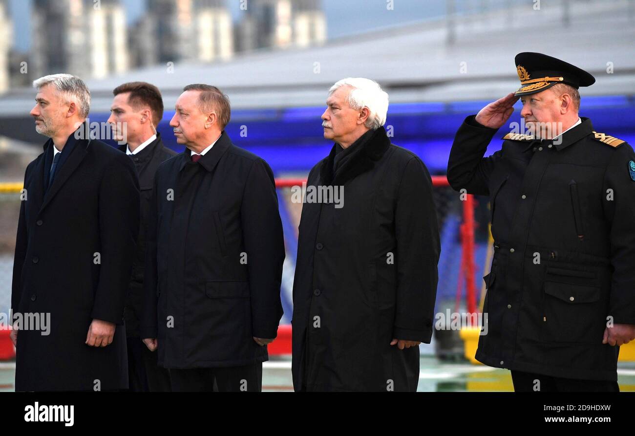 St. Petersburg Gouverneur Alexander Beglov, Mitte, Vorsitzender der United Shipbuilding Corporation Georgy Poltavchenko, rechts, und andere Beamte stellen sich für eine Flaggenanhebung Zeremonie an Bord des neuen Diesel-elektrischen Eisbrechers Viktor Chernomyrdin dockte an der Admiralty Shipyard 3. November 2020 in St. Petersburg, Russland. Stockfoto