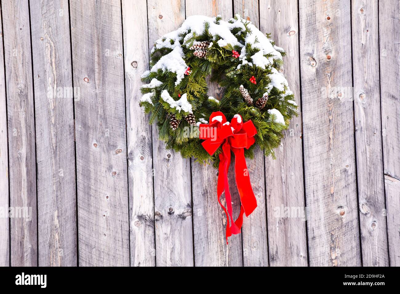 Verschneiten Weihnachtskranz an einer Scheune in Craftsbury, VT, New England, USA. Stockfoto