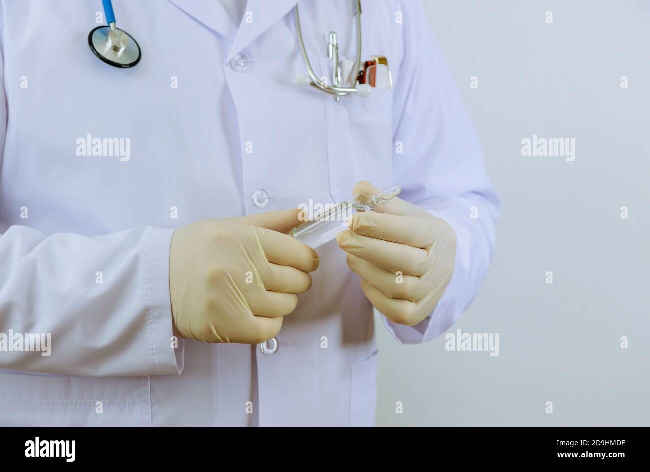 Das Medikament Handschuhe Arzt hält eine Ampulle für die Impfung Behandlung In seiner Hand konzentrieren sich auf die Ampulle Stockfoto