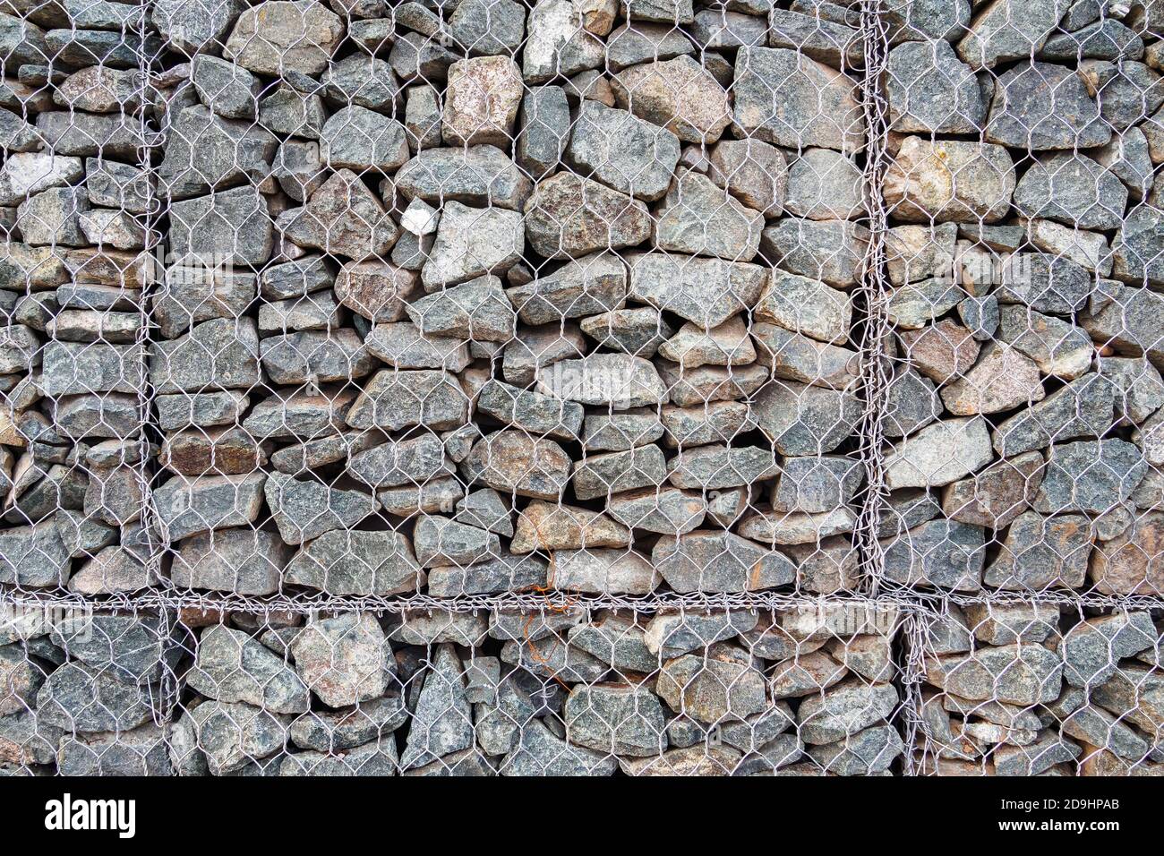 Nahaufnahme von Gabion, Zaun aus Steinen in Metallgeflecht für den Einsatz im Tiefbau, Straßenbau Landschaftsbau. Stockfoto