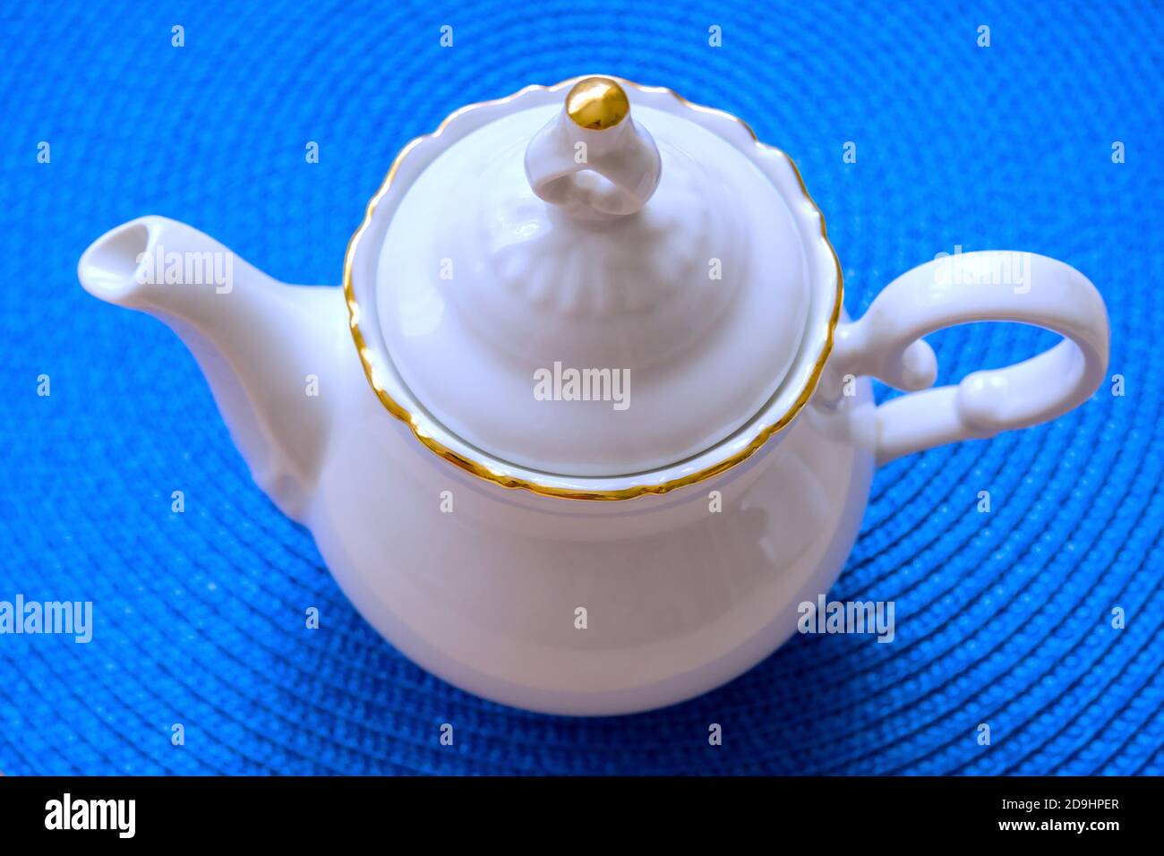 Weiße Teekanne auf einem Hintergrund von blauen Korbmatte, weiche selektive Fokus Stockfoto