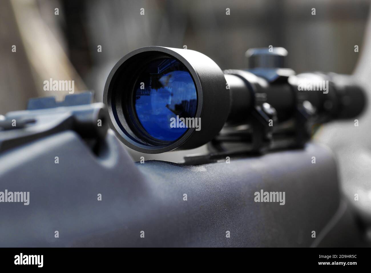 Nahaufnahme der Teleskopsicht mit Reflexion in der Linse montiert auf Gewehr für Scharfschützenschießen Stockfoto