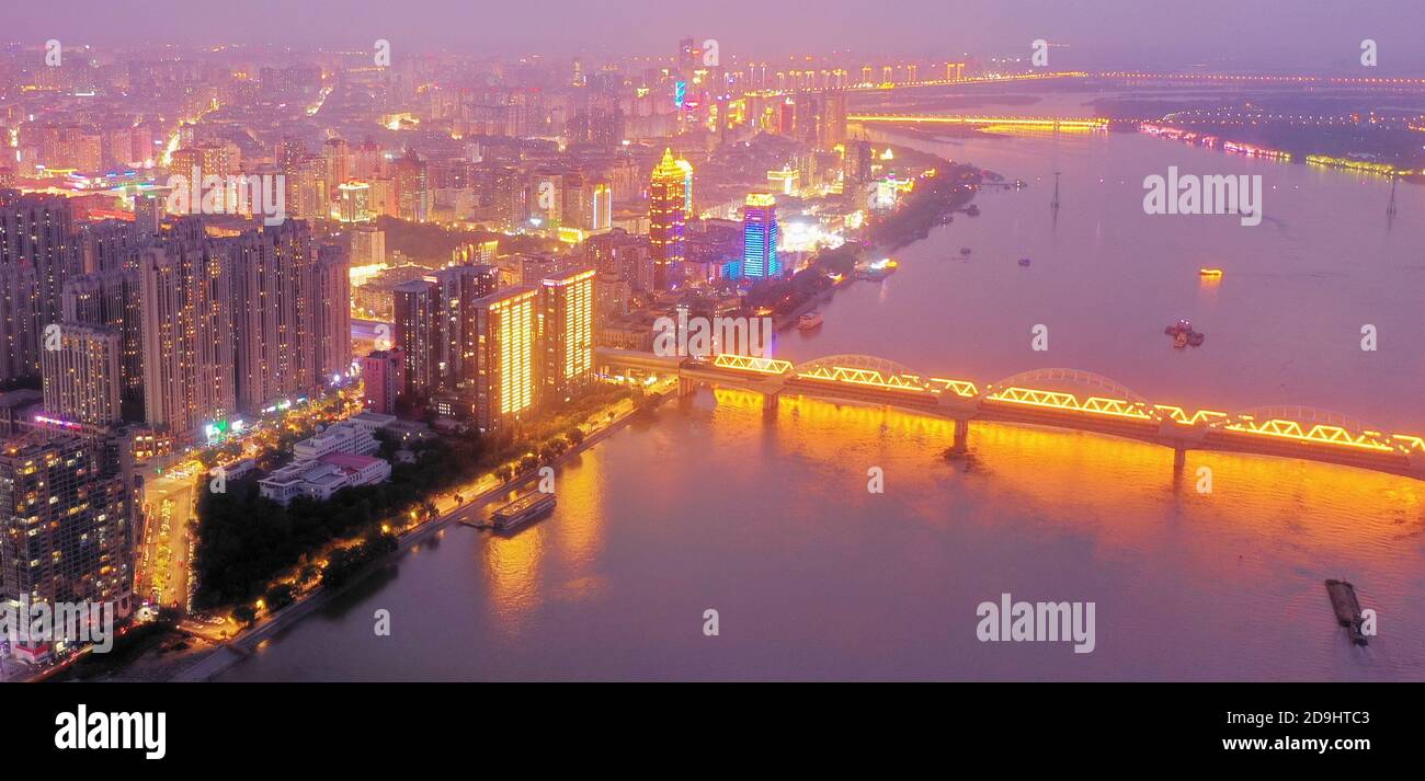 Eine Luftaufnahme des gesamten Stadtgebiets, das bei Nacht aufleuchtet und Lampen in Häusern, Automobillampen und Straßenlampen eingeschaltet werden, Harbin c Stockfoto