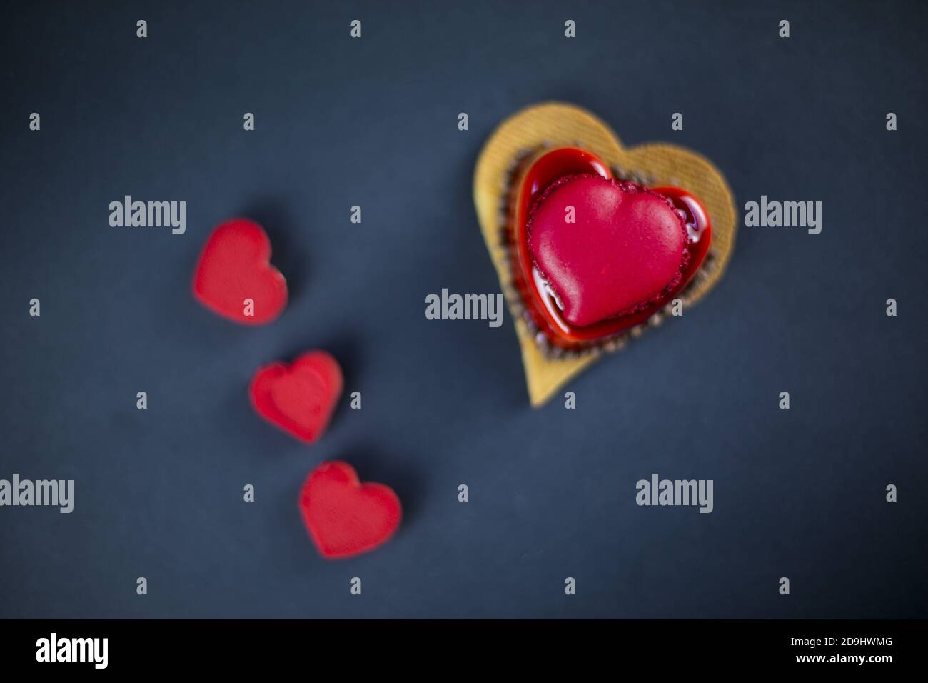 Herzförmiger Mini-Kuchen mit rotem Karamell und Mousse bedeckt Stockfoto