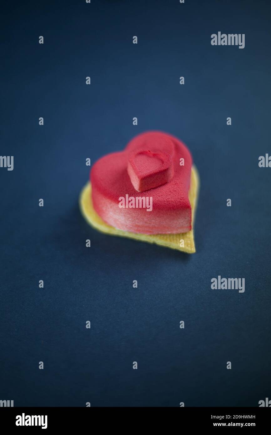 Herzförmige Mousse Mini-Kuchen auf dem dunkelblauen Hintergrund Stockfoto