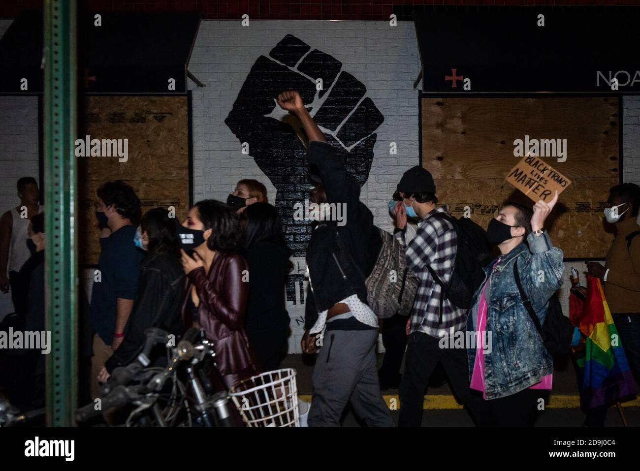 Ein Protestler geht mit erhobener Faust an einer schwarzen Machtfaust vorbei während des "We Choose Freedom" marsches in New York City am 5. November 2020. (Foto von Gabriele Holtermann/Sipa USA) Quelle: SIPA USA/Alamy Live News Stockfoto