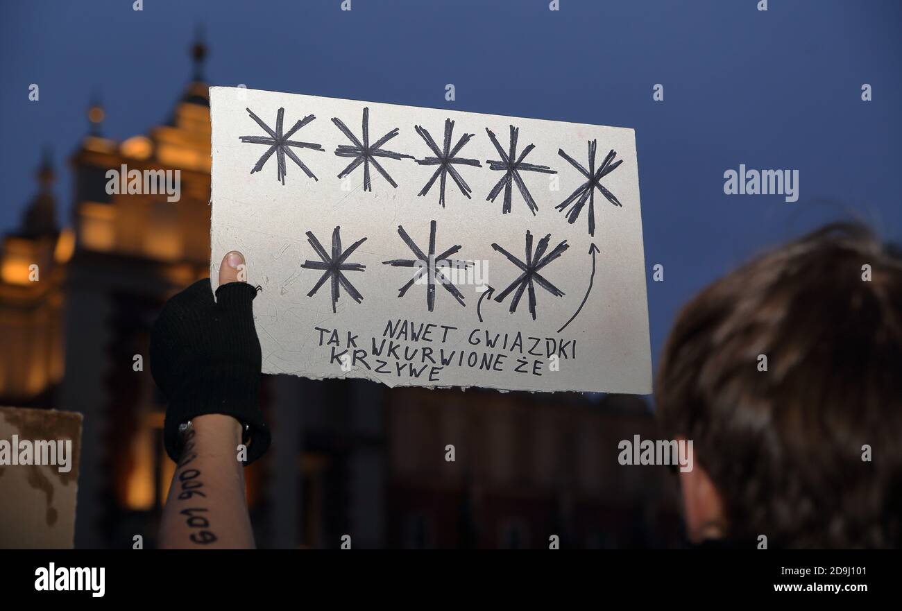 Krakau, Polen - 2020. November: Junger Mann nimmt an der Demonstration der Anti-Regierung- und Rechts- und Justizpartei in Krakau Teil und hält ein Plakat mit symbolischen 8 Sternen Stockfoto