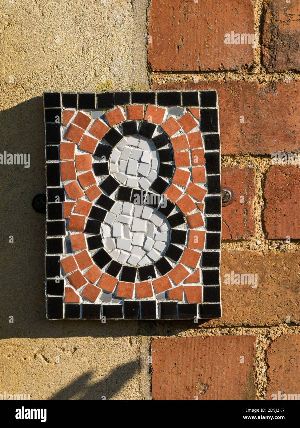 Nahaufnahme des kleinen, hübschen, Nummer acht (8) Mosaikfliesen Hausnummer Zeichen, Großbritannien Stockfoto