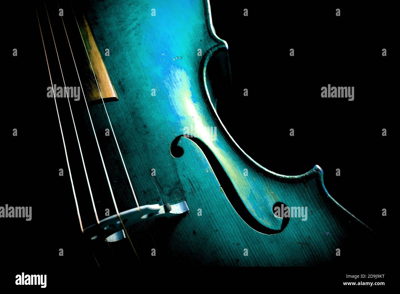Cello in lebendiger aquabluer Farbe auf schwarzem Hintergrund. Stockfoto