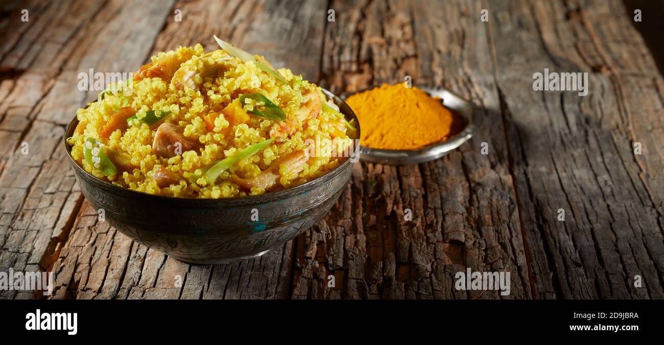 SAFRON farbige oder Kurkuma aromatisierte Schüssel von vorbereitet Couscous und Quinoa als Beilage auf einem serviert werden Alt verwitterter Holztisch mit Copyspace i Stockfoto