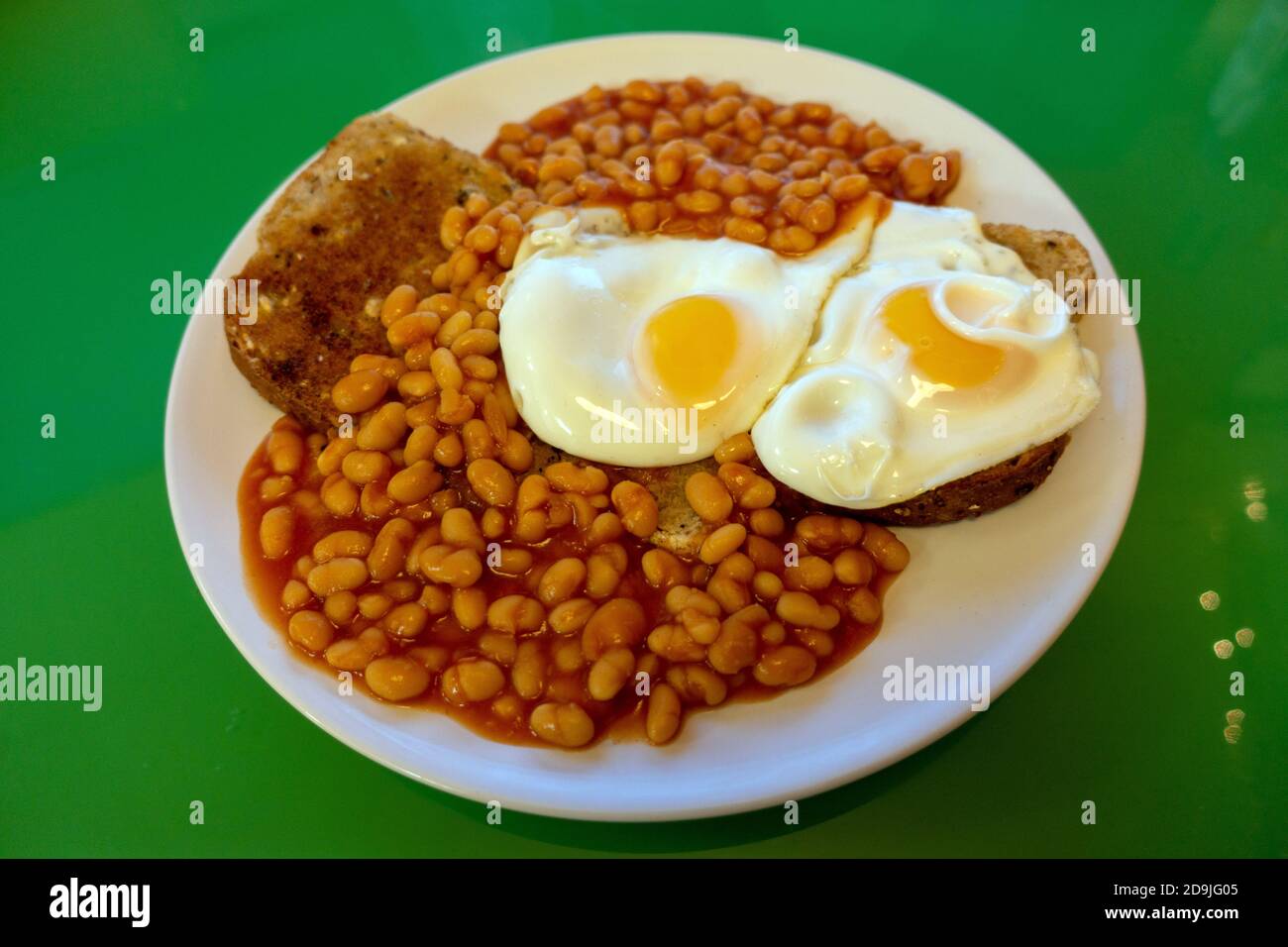 Bohnen auf Toast mit 2 Spiegeleiern Stockfoto
