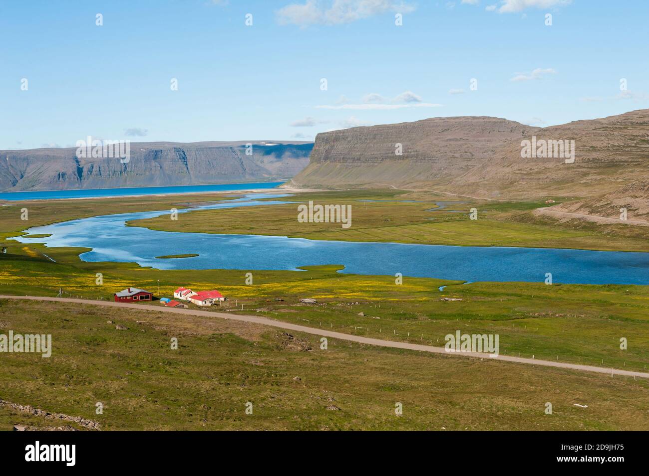 Mächtige Fjorde erheben sich aus dem Meer und einem Bauernhof. Westfjorde Halbinsel, nordwestlich von Island Stockfoto