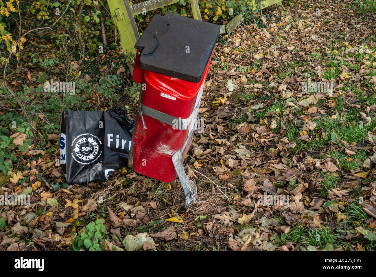 Gedumpte Tasche fürs Leben hinter Mülltonne in einem Holz Stockfoto