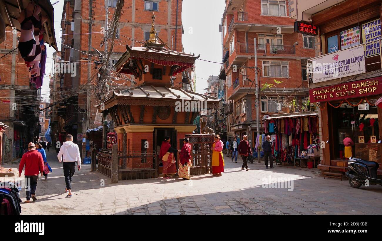 Kathmandu, Nepal - 11/11/2019: Geschäftige Szene um kleine Pagodentempel in den engen Straßen des Touristenviertels Thamel im Zentrum von Kathmandu. Stockfoto
