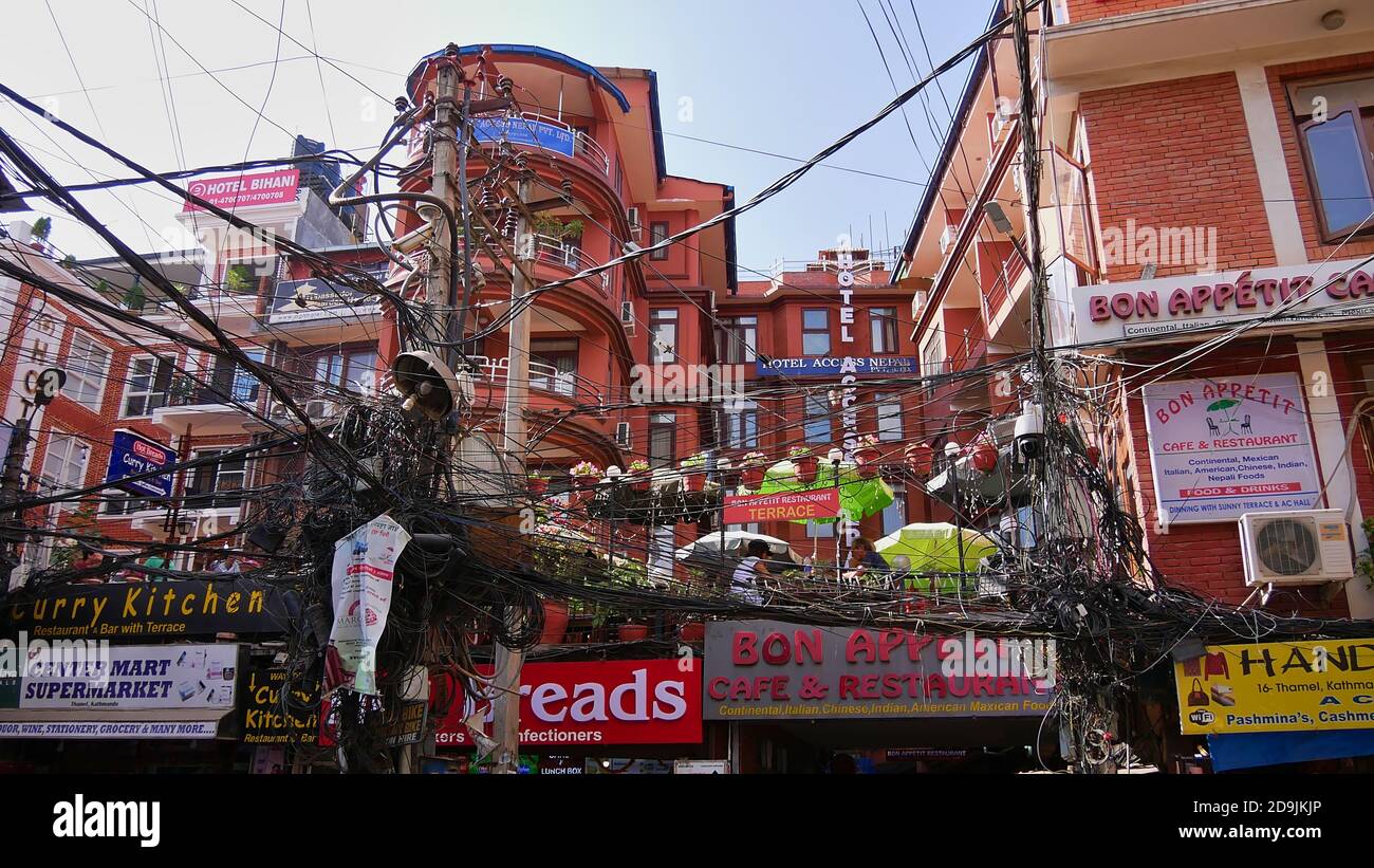 Kathmandu, Nepal - 11/11/2019: Gebäude im Touristenviertel Thamel im Zentrum von Kathmandu, hauptsächlich Geschäfte und Hotels, mit einem riesigen Wirrwarr von Stromkabeln. Stockfoto