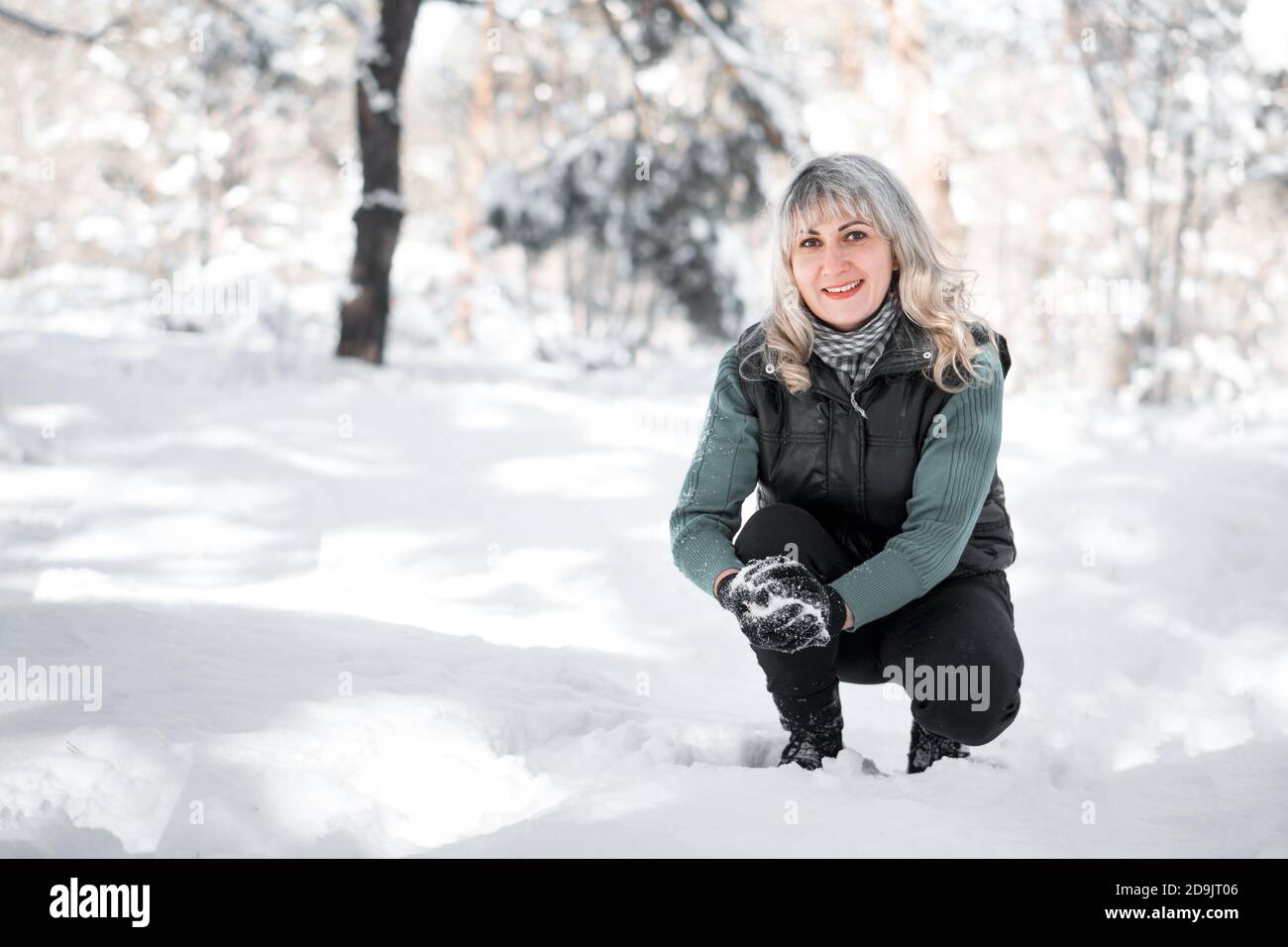Frau spielt Schneebälle im Park. Camping und Winter Konzept. Stockfoto