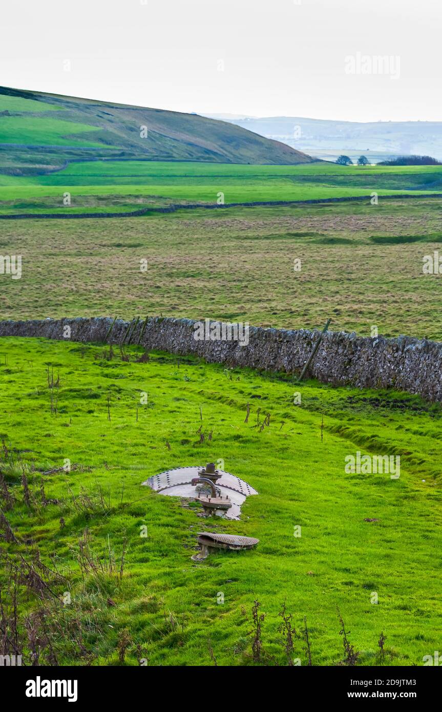 Ein alter Stahlblechkessel versank in den Boden, um als Wassertank in der Nähe des Standorts der Mine Portaway in der Nähe von Castleton, Derbyshire, verwendet zu werden. Stockfoto