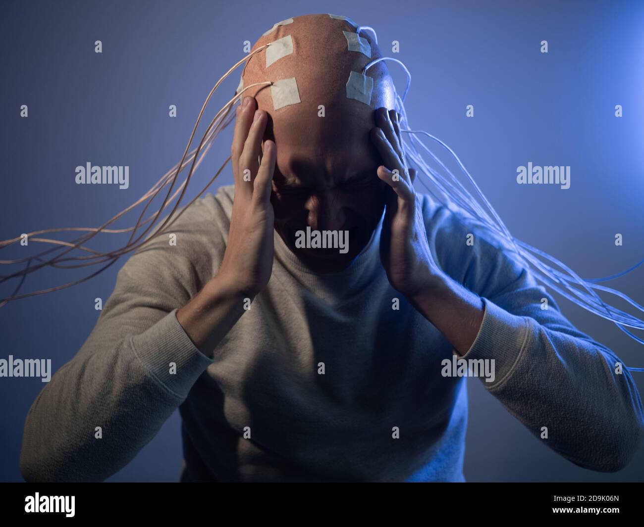 Person mit Implantaten im Kopf erlebt Stress und Schrecken. Neue Technologien, Augmented Brain, Neuroschnittstelle und Virtualität. Stockfoto