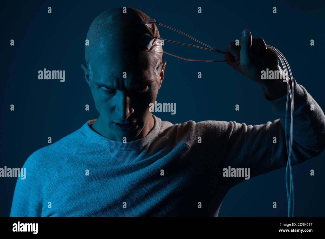 Glatze Mann mit Elektroden in seinem Gehirn, ein Mann der Zukunft mit technologischen Ergänzungen, ist das Gehirn mit der virtuellen Realität verbunden. Stockfoto