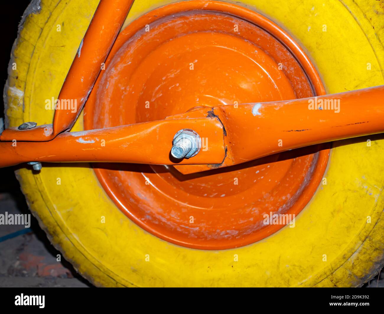Ein gelbes Rad mit einer orangefarbenen Scheibe einer Gartenrampe. Stockfoto