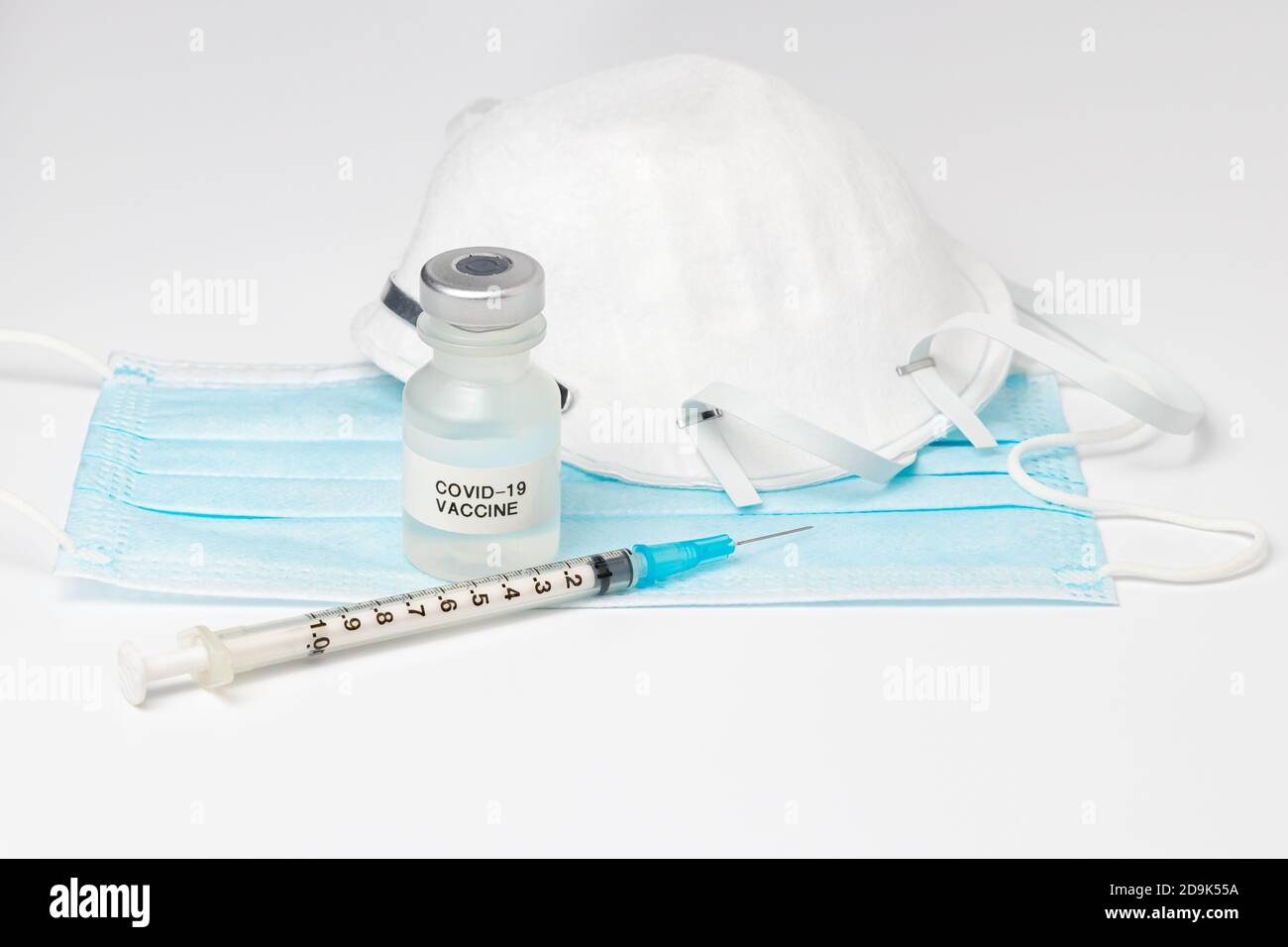 Fläschchen mit Covid-19-Impfstoff, Spritze und Nadel und Gesichtsmaske N95 isoliert auf weißem Hintergrund. Konzept der Coronavirus-Pandemie, Immunisierung Stockfoto