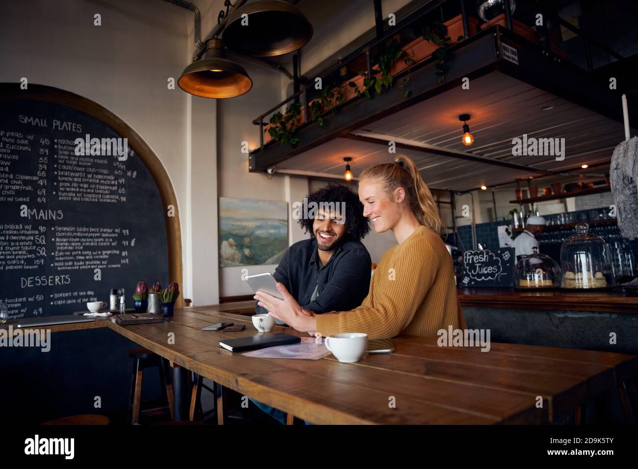 Glückliches junges Paar sitzen und entspannen im Café mit digitalen Tablet, um Videos anzusehen Stockfoto