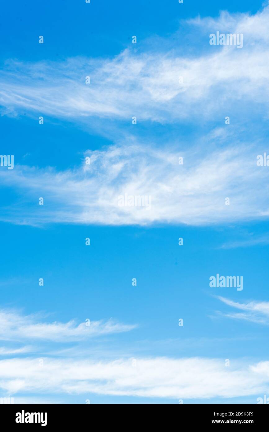 Weiße, wispige Wolken auf einem strahlend klaren blauen Himmel Stockfoto