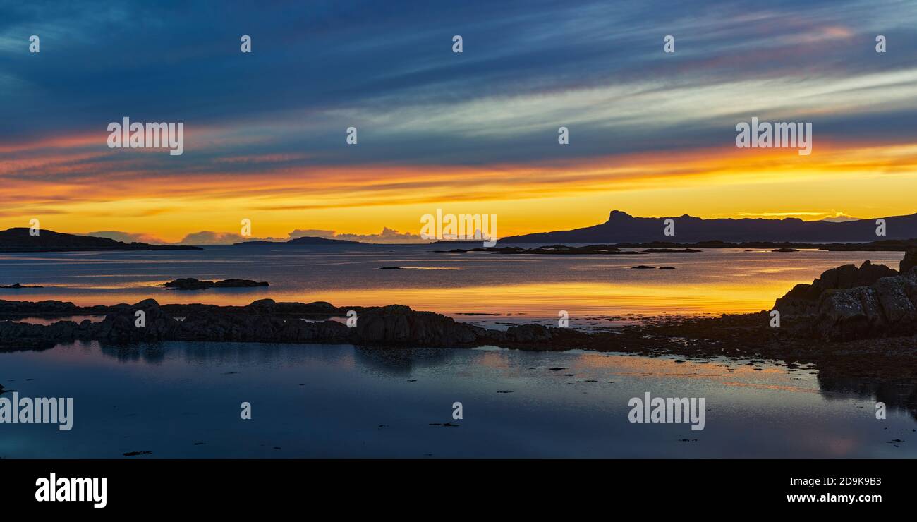Sonnenuntergang über der Insel Eigg in den kleinen Inseln, von der Rhu-Halbinsel aus gesehen, Arisaig, Lochaber, Highland, Schottland. Panorama. Stockfoto