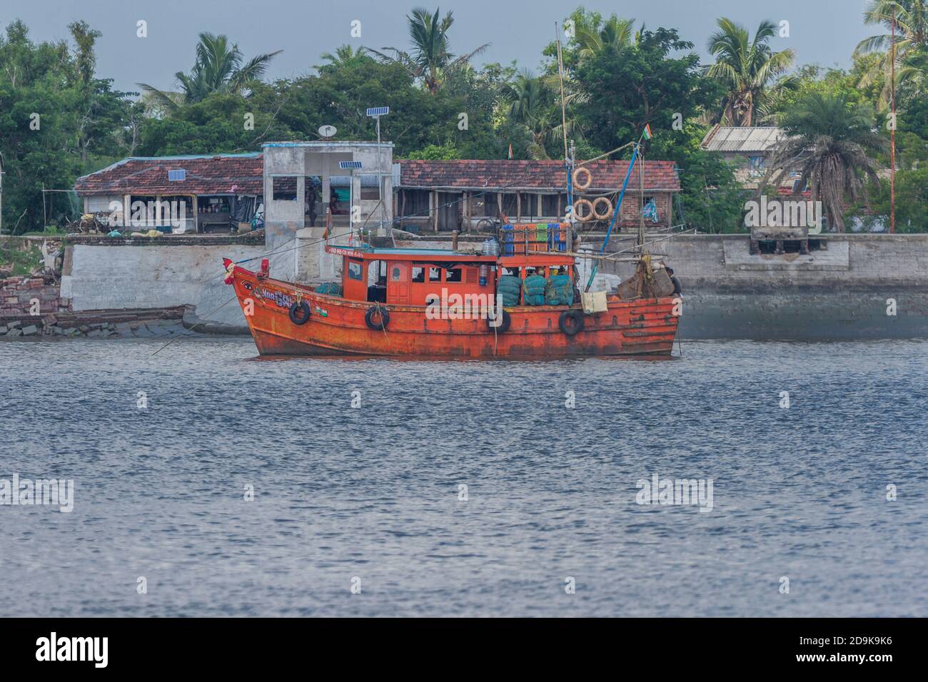 Orangefarbenes Boot, das für Angelaktivitäten in der Tiefsee verwendet wird, verankert in der Nähe einer Dorfinsel in Sundarban, Westbengalen, Indien am 16. Oktober 2020 Stockfoto