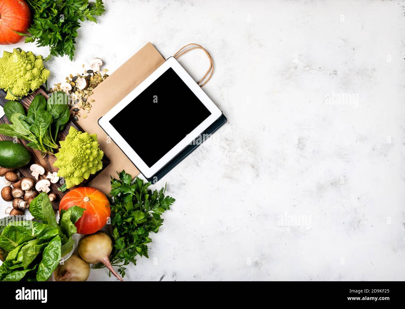 Online-Lebensmittelgeschäft Konzept. Tablet-Computer und Einkaufstasche mit verschiedenen Gemüse und Gemüse. Draufsicht Stockfoto