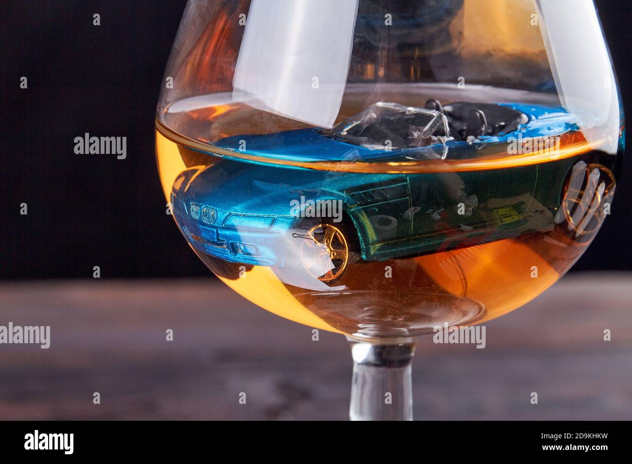 Nahaufnahme ertränkt blaues Auto in einem Glas Brandy. Stockfoto