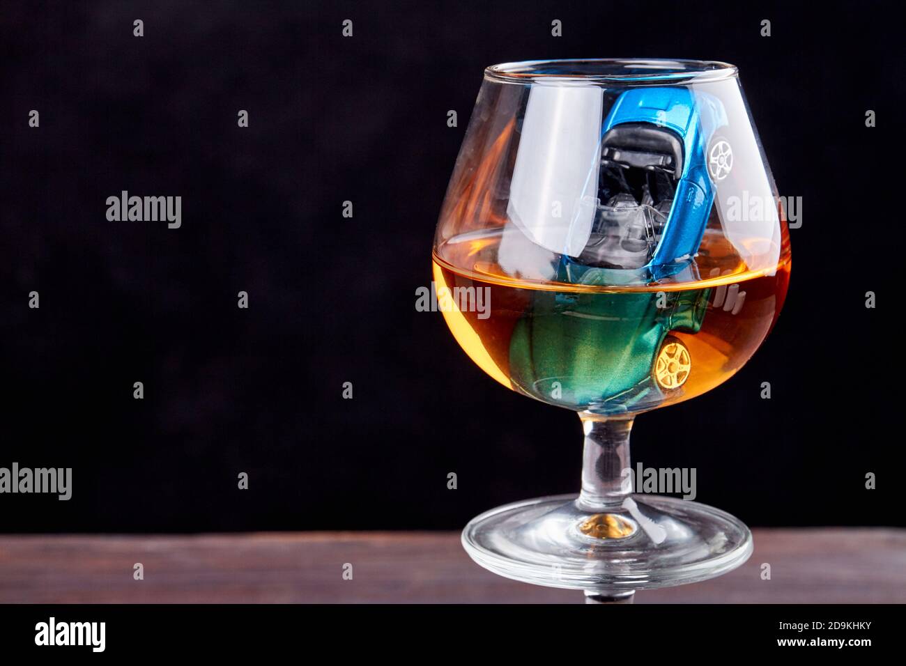 Komposition mit Mini-Auto in einem Glas Whiskey. Stockfoto