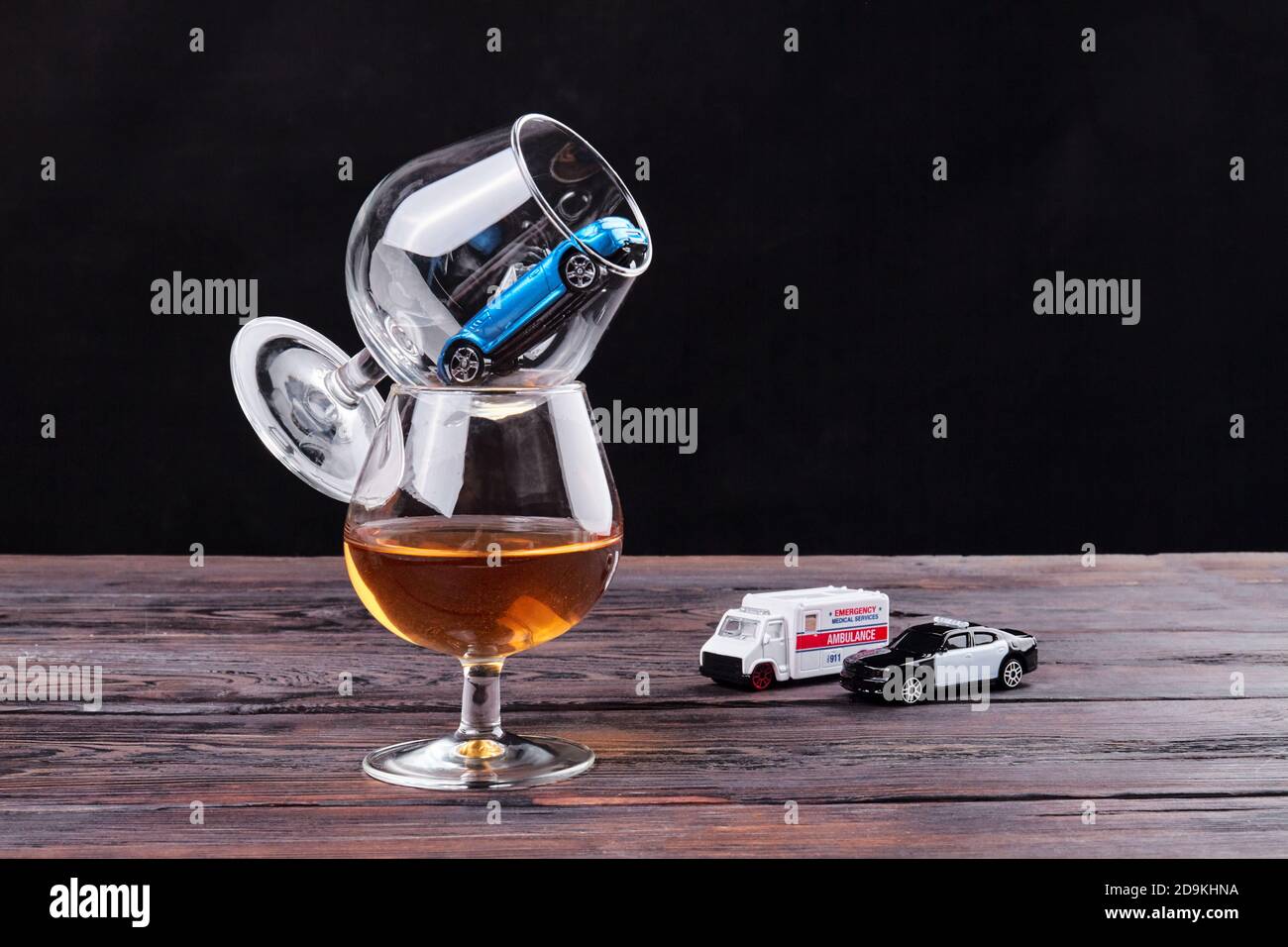 Zusammensetzung von Gläsern für Alkohol und Spielzeugautos. Stockfoto