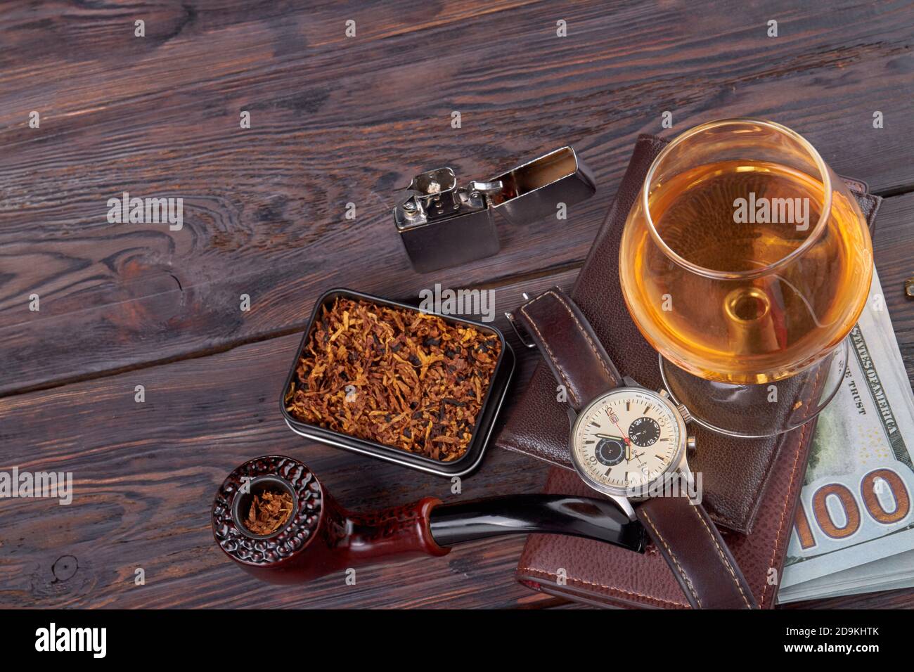 Rauchpfeife mit Tabak und Glas Brandy. Stockfoto