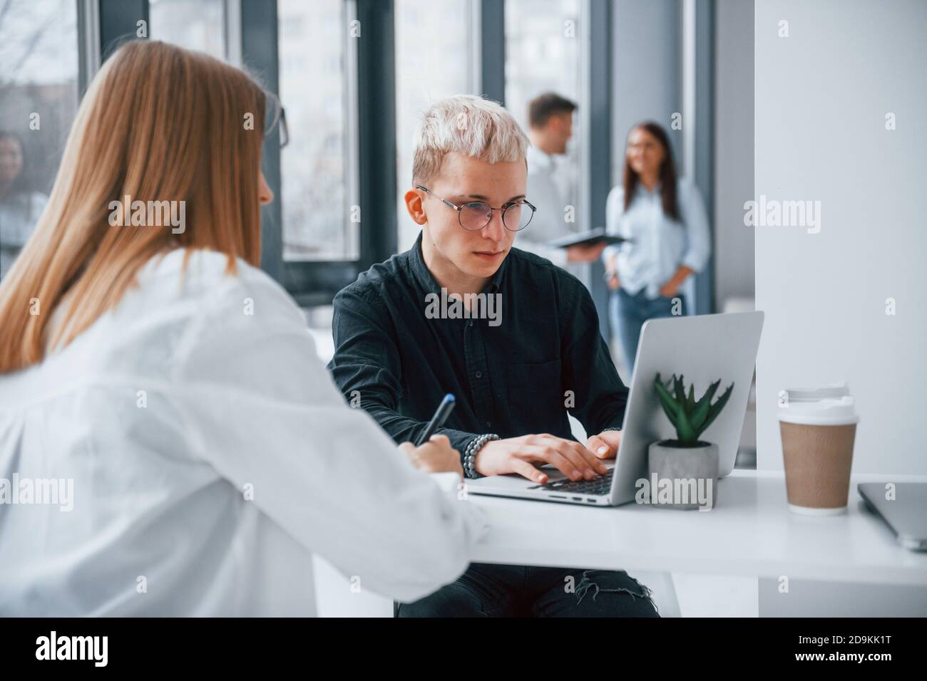 Frau und Hipster Mann vor Gruppe von jungen Erfolgreiches Team, das im Büro gemeinsam arbeitet und kommuniziert Stockfoto