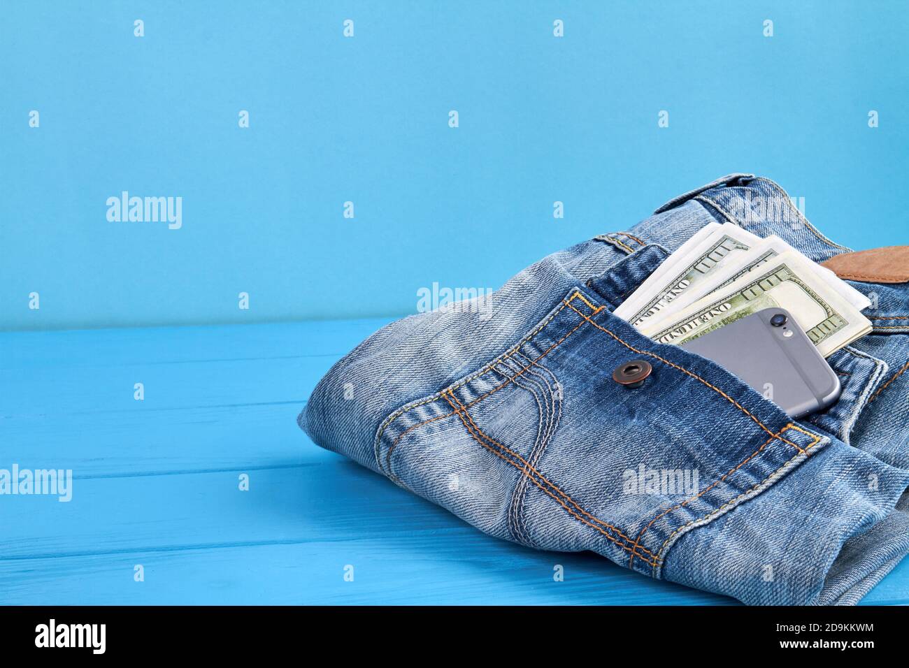 Jeans mit Geld und Smartphone in der Gesäßtasche. Stockfoto