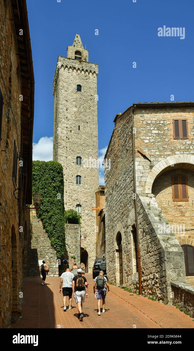 Blick auf die Straße des historischen Zentrums von San Gimignano, UNESCO-Weltkulturerbe, mit Torre Grossa mittelalterlichen Turm und Touristen, Siena, Toskana, Italien Stockfoto