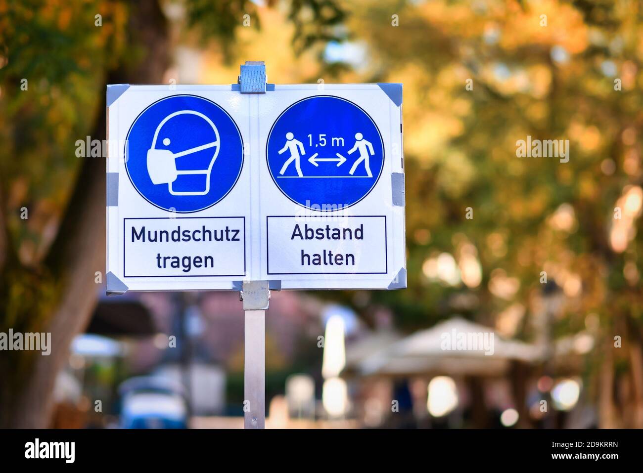 Schilder für Gesichtsmaske und Abstand Anforderung in deutscher Stadt Zentriert mit Text „Gesichtsmaske tragen“ und „Abstand halten“ Stockfoto