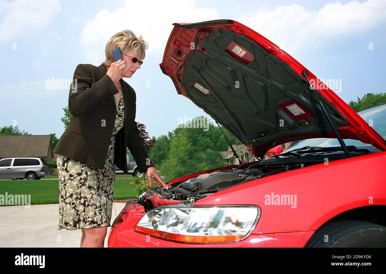 Professionelle weibliche nutzt Handy außerhalb aufgeschlüsselt Automobil Stockfoto