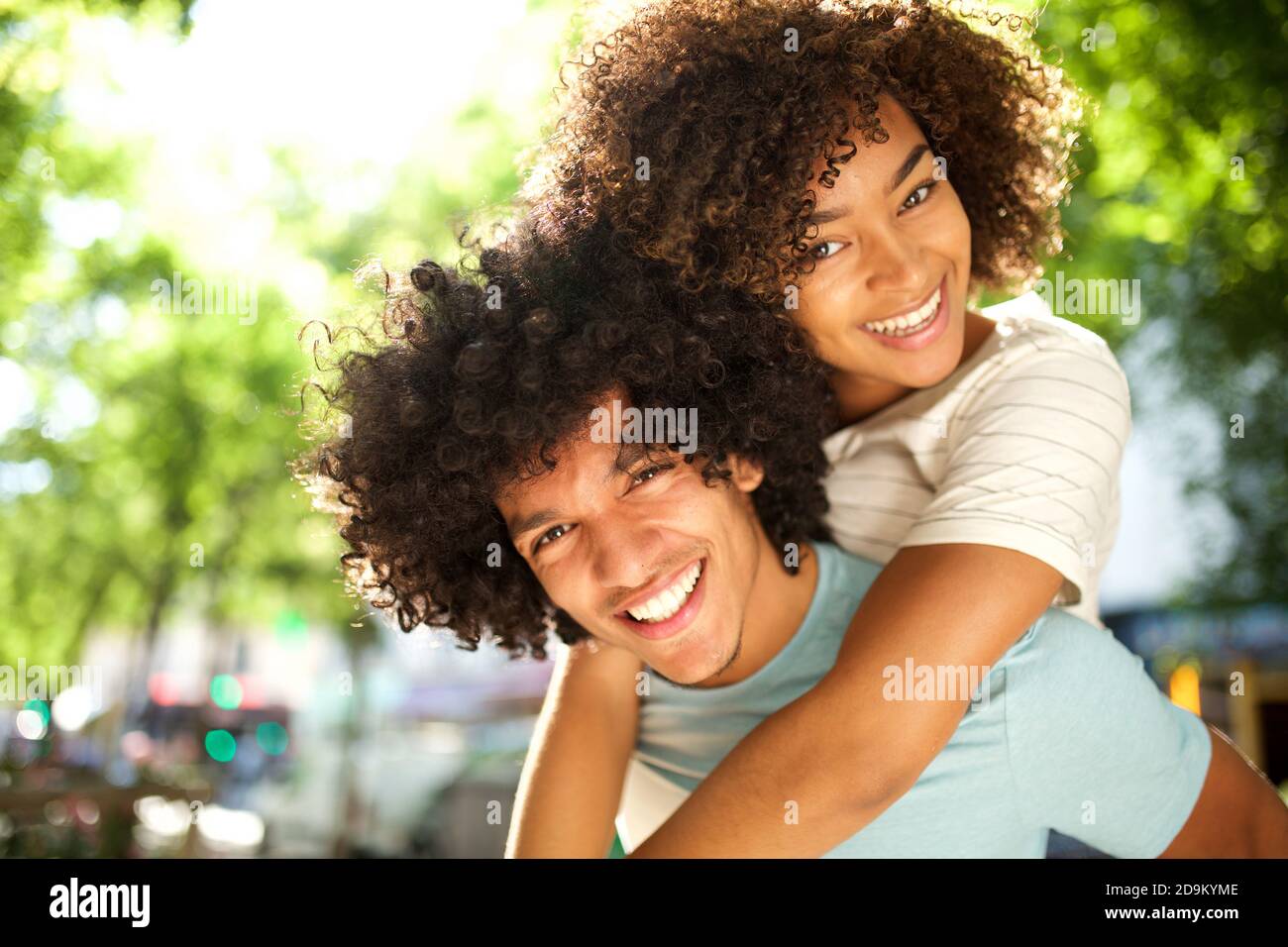 Nahaufnahme Porträt glücklich afroamerikanischen Mädchen auf Boyfriends zurück Stockfoto
