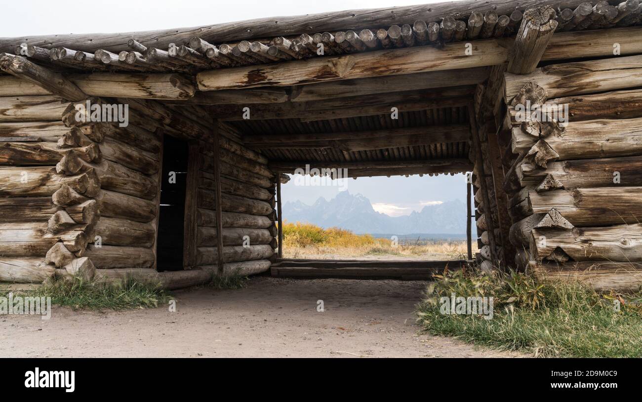 Die alte historische Cunningham Ranch Hütte im Grand Teton National Park wurde von J.P Cunningham im Jahr 1888 gebaut. Dahinter stehen Grand Teton und der Teton Stockfoto