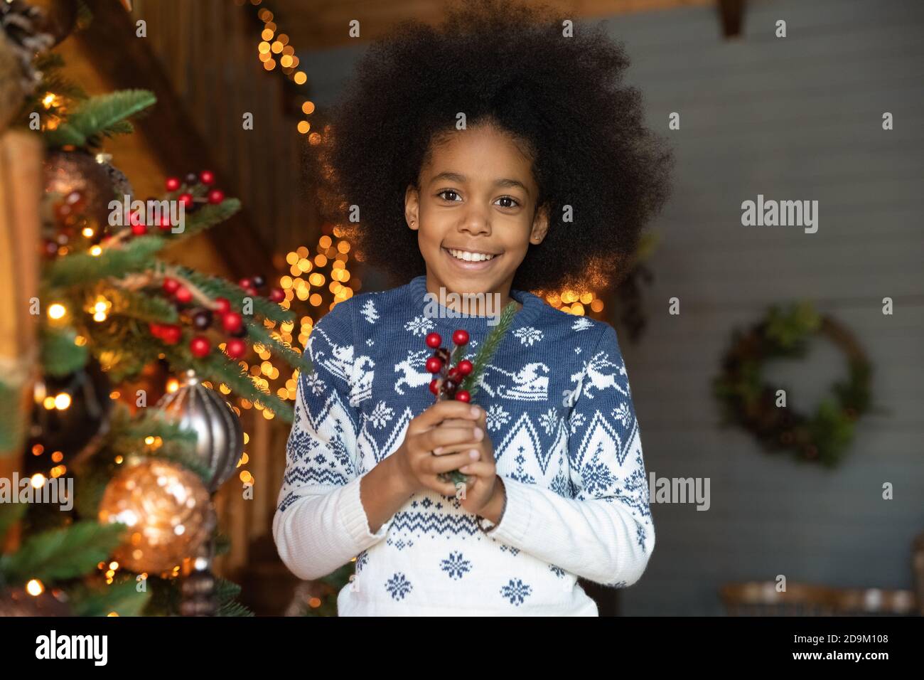 Kopf erschossen Porträt lächelnd afroamerikanische Mädchen hält Weihnachtskugel Stockfoto