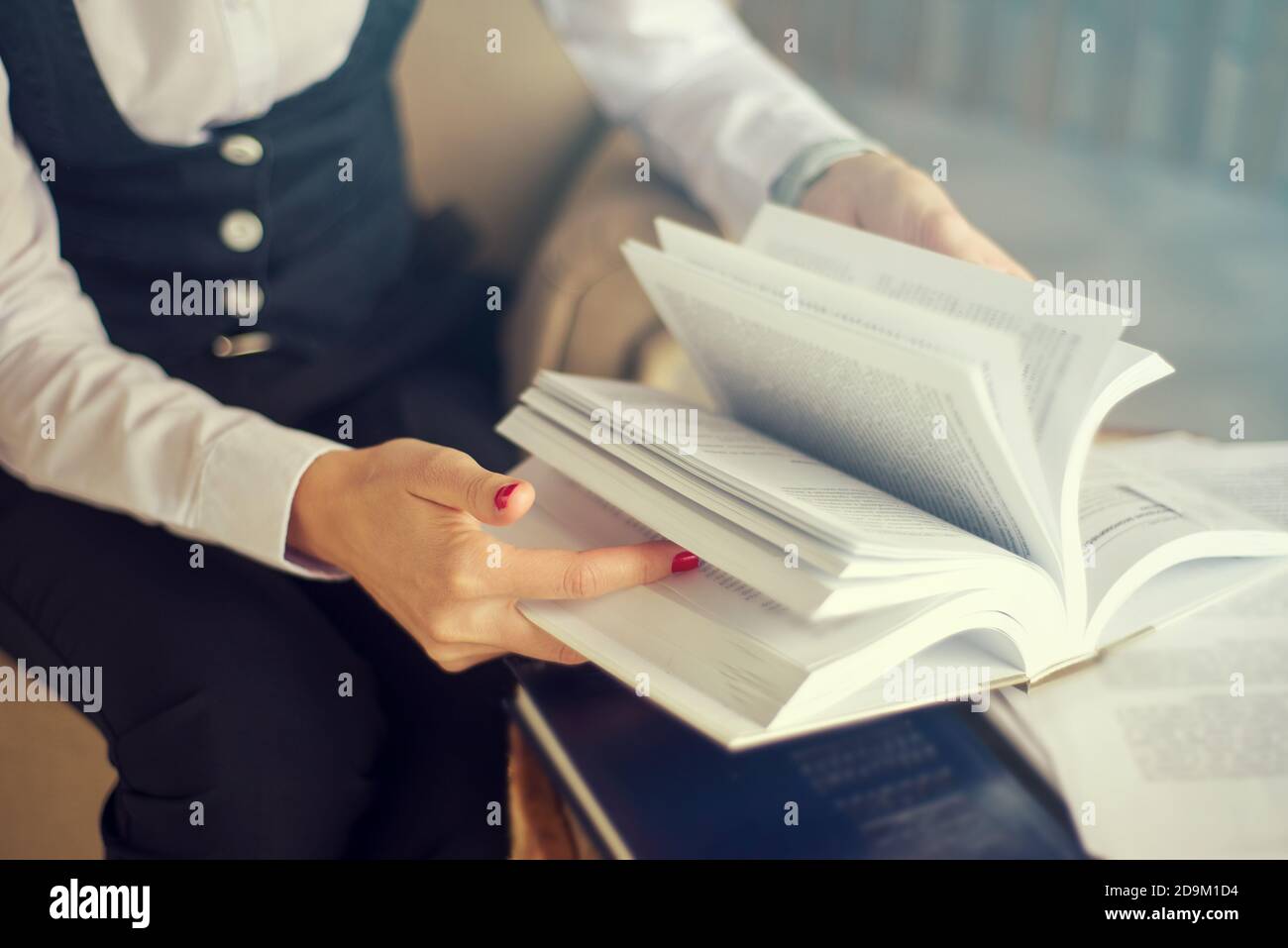 Geschäftsfrau, Sekretärin oder Studentin blättert durch ein Buch Stockfoto