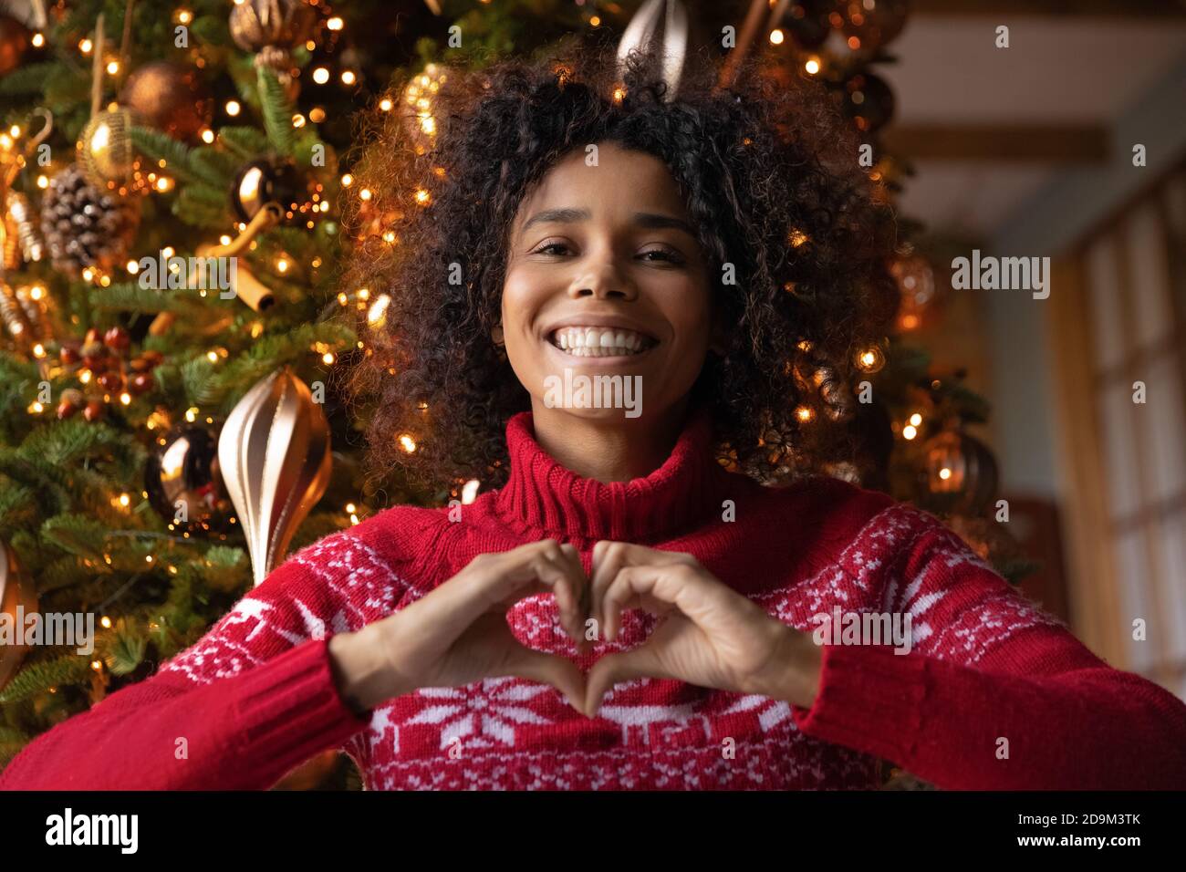 Kopf erschossen Porträt lächelnd afroamerikanische Frau zeigt Herz Geste Stockfoto