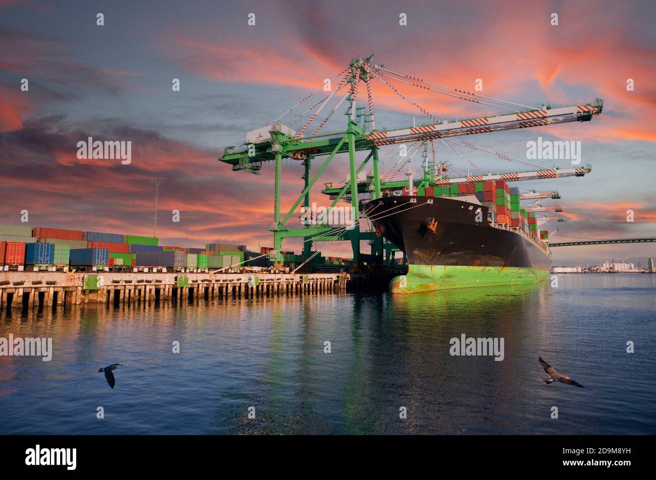 Container, Kräne und Hafenschiff mit Sonnenuntergang Himmel. Stockfoto