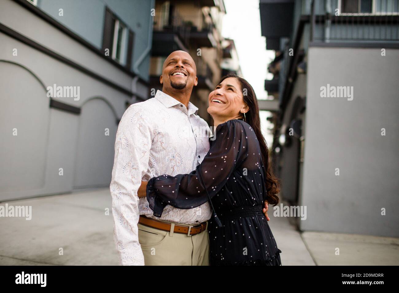 Ende der vierziger Jahre lachendes Paar, das in der Gasse in San Diego steht Stockfoto