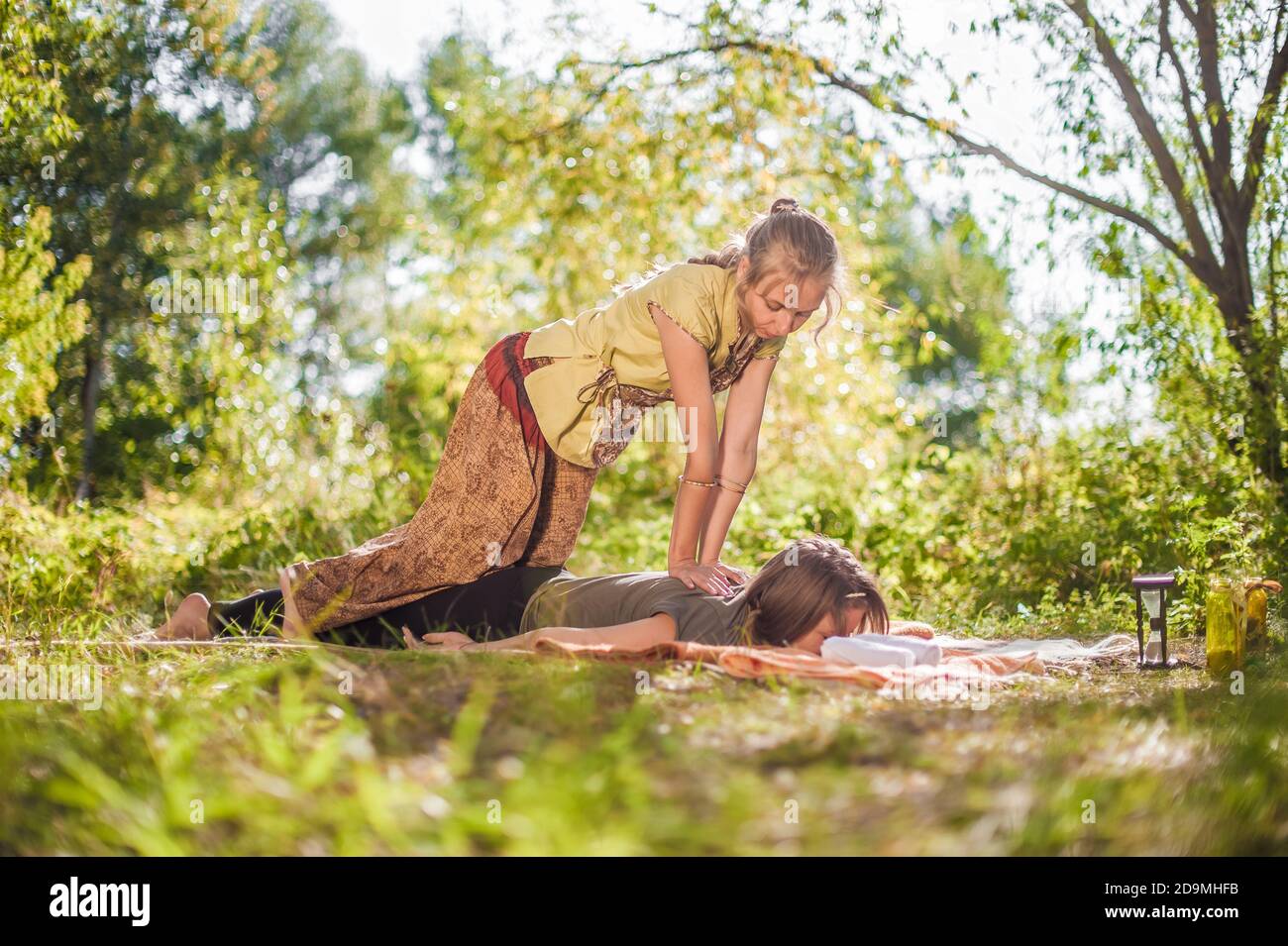 Die Massagetherapeutin impliziert ihre Massagefähigkeiten auf dem Waldboden. Stockfoto