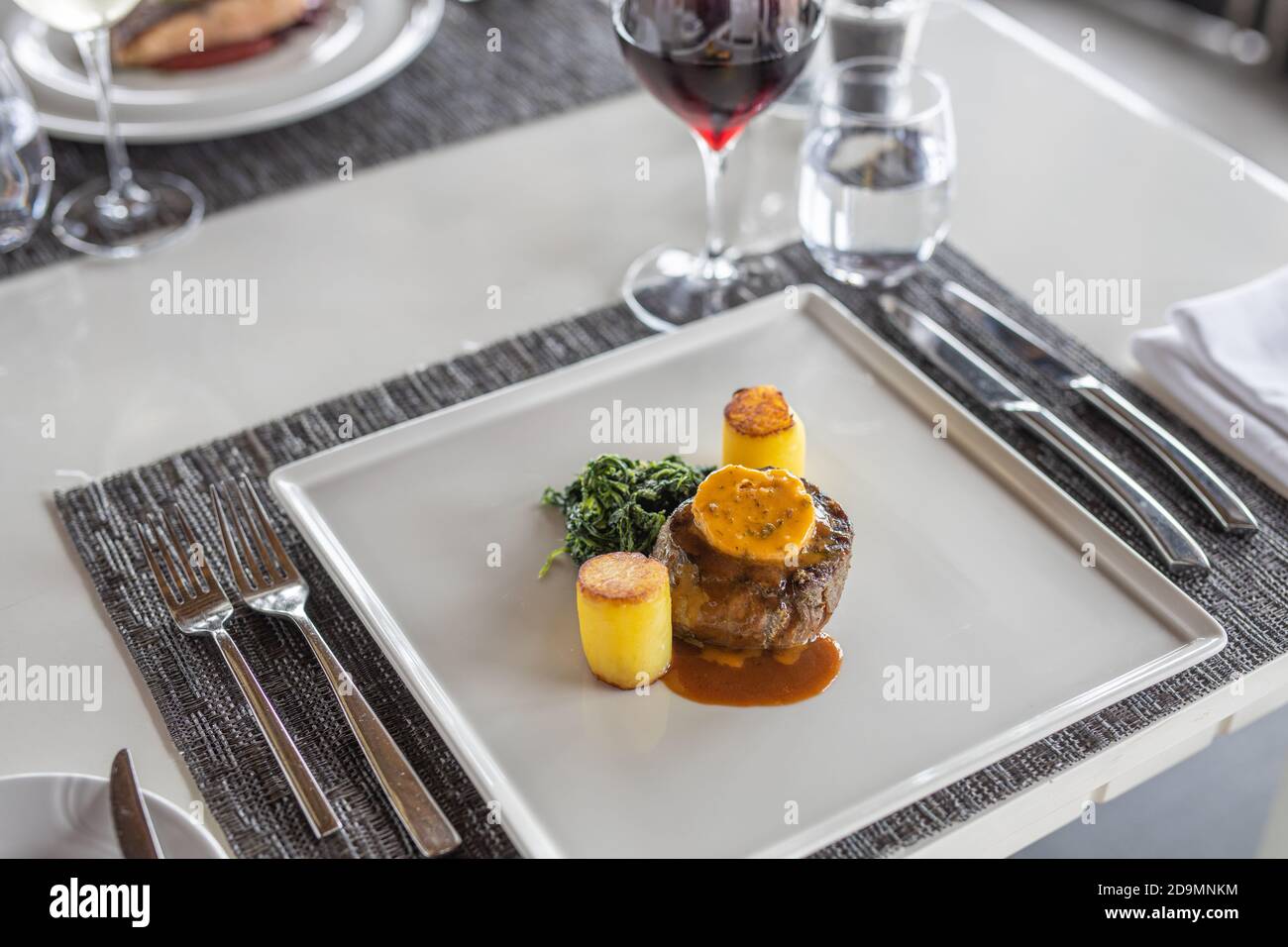 Tisch im Restaurant serviert. Luxus-Tisch-Einstellung, Gourmet-Essen Hintergrund. Essen im eleganten, erstklassigen Restaurant, moderner Tisch Stockfoto